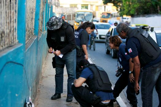 salvador, bahia, brazil - october 15, 2015: Agents from the homicide police station and experts carry out an investigation in the place where a man was murdered in the neighborhood of Sussuarana in Salvador.