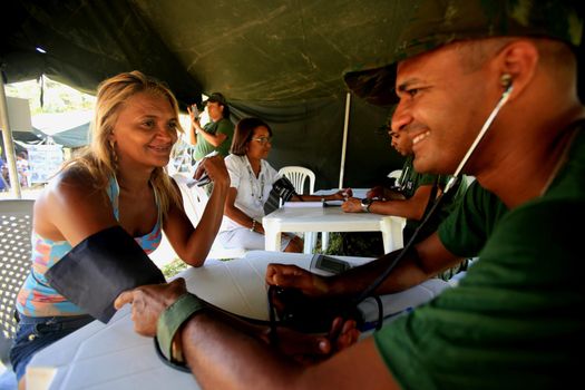 salvador, bahia / brazil - november 4, 2015: nurse in the brazilian navy measures a person's blood pressure during social action on Ilha de Mare, in the city of Salvador.