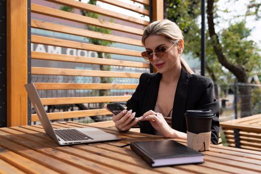 young woman businesswoman working in a cafe on the street.