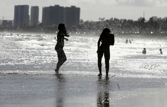 salvador, bahia, brazil - december 22, 2015: Young people are seen in the water of Placafor beach in Salvador city.