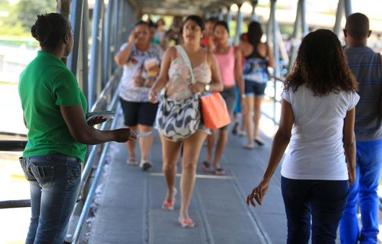 salvador, bahia, brazil - november 12, 2015: Young man is seen handing out advertising leaflets in front of a pedestrian crossing in the city of Salvador.