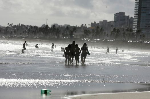 salvador, bahia, brazil - december 22, 2015: Young people are seen in the water of Placafor beach in Salvador city.