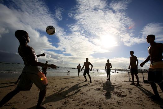 salvador, bahia, brazil - december 22, 2015: Young people are seen playing soccer on Itapua Beach in Salvador