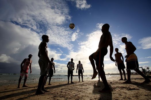 salvador, bahia, brazil - december 22, 2015: Young people are seen playing soccer on the sand of Itapua beach in the city of Salvador.