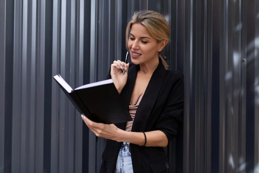 office worker woman studying her schedule in the office against a gray wall.