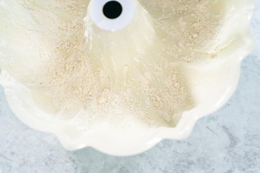 Close up view. Greasing bundt cake pan with vegetable shortening and flour to bake funfettti bundt cake.