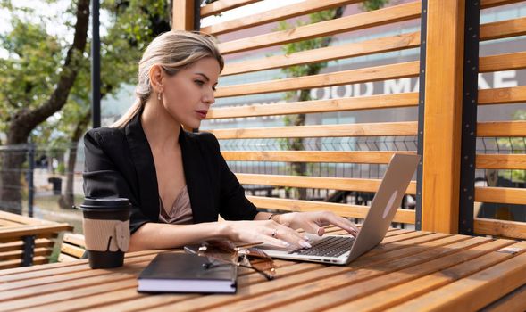 Business woman working on a laptop in the city.