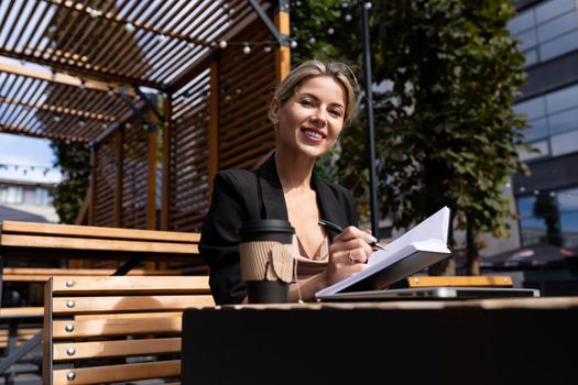 young woman running outdoors on the terrace with a smile looking at the camera.
