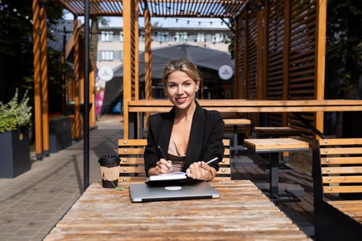woman head working outdoors with laptop diary.