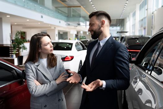 a young woman negotiates a long-term car rental at a car dealership.