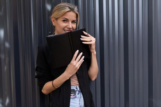 young office worker woman with weekly planner on gray wall background.