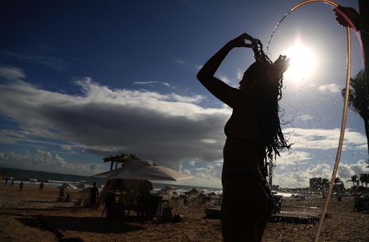 salvador, bahia / brazil - december 22, 2015: Woman taking a shower in Placafor beach in Salvador.
