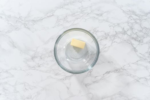 Flat lay. Melting stick of unsalted butter in a microwave.