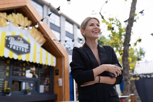 portrait of a smiling successful business woman on the background of a street cafe.