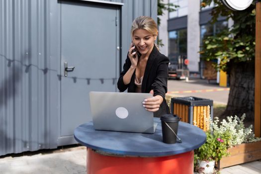 portrait of a successful young woman working in a cafe behind a laptop.