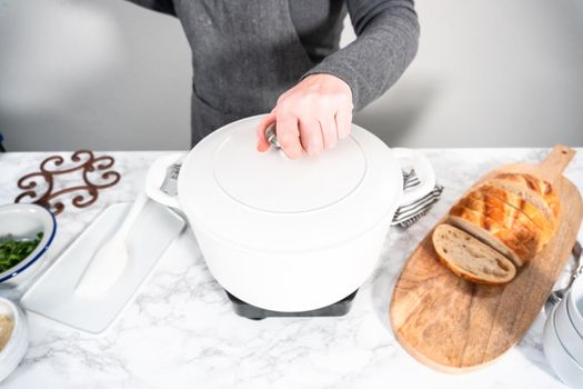 Cooking vegetarian white bean soup in cast iron dutch oven.