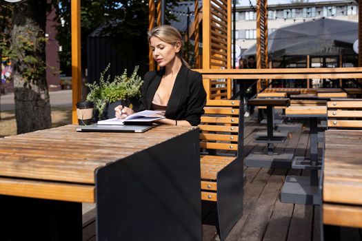 young business woman sitting in a cafe with a laptop diary.