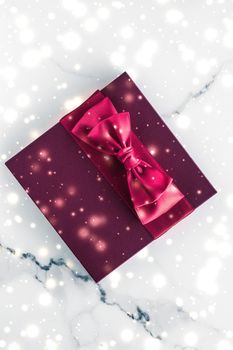 New Years Eve celebration, wrapped luxury boxes and cold season concept - Winter holiday gifts with cherry silk bow and glowing snow on frozen marble background, Christmas presents surprise