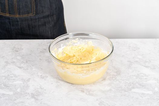 Mixing ingredients in a glass mixing bowl to bake July 4th bundt cake with chocolate stars.