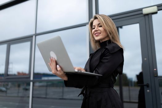 online work concept of a modern woman on the background of an office building.