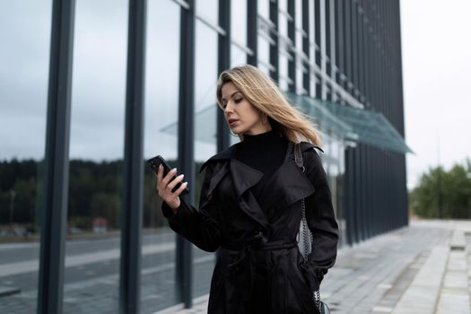 successful middle-aged businesswoman looking at the phone on her way to work.