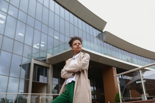 portrait of a serious young black woman on the background of a modern city building.