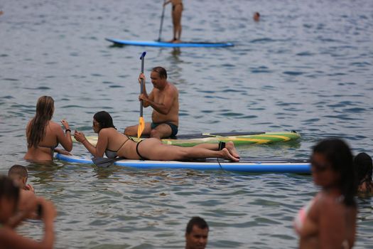 salvador, bahia / brazil - february 21, 2016: People are seen practicing stand up pedal on the beach of Porto da Barra, during the summer of the city of Salvador.