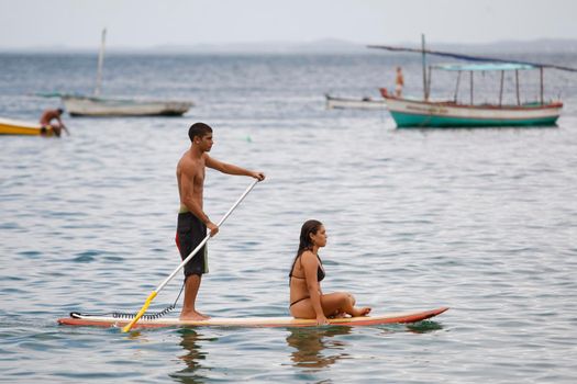salvador, bahia / brazil - february 21, 2016: People are seen practicing stand up pedal on the beach of Porto da Barra, during the summer of the city of Salvador.