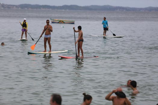 salvador, bahia / brazil - february 21, 2016: People are seen practicing stand up pedal on the beach of Porto da Barra, during the summer of the city of Salvador.