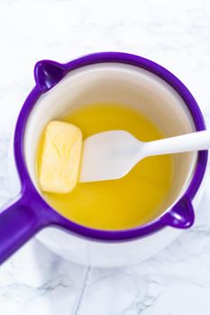 Melting stick of unsalted butter in candy melting pot.