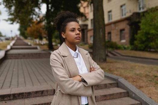 young successful black woman entrepreneur in business clothes on the background of the city stairs. Concept of career growth