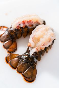 Preparing raw lobster tails to make garlic lobster tails.