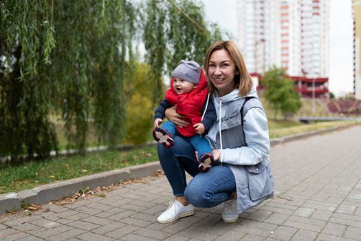happy young mother on the background of the city with her little child.