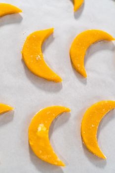 Lemon wedge cookies with lemon glaze. Rolling cookie dough with an adjustable rolling pin and cutting out cookies with cookie cutters to bake lemon wedge cookies with lemon glaze.