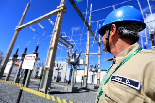 lauro de freitas, bahia / brazil - august 10, 2016: technician observes wiring in a Coelba substation in the Itinga neighborhood in the city of Lauro de Freitas.
