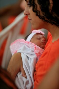 salvador, bahia / brazil - july 25, 2016: Inmate of the Female Presidio of Salvador holds her son during an event in the prison unit.


