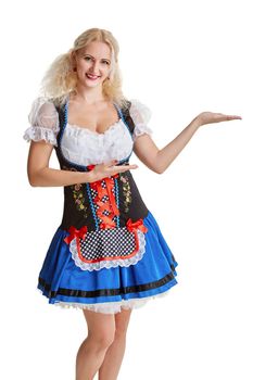 Beautiful young blond girl in dirndl drinks out of oktoberfest beer stein. Isolated on white background. pointing finger and smiling. copyspace desing concept