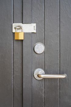 Image of Modern style door handle on the black painted wooden door and locks