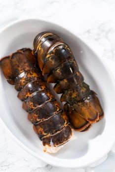 Preparing raw lobster tails to make garlic lobster tails.