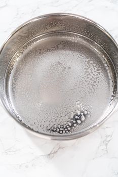 Greasing pressure cooker insert with cooking spray oil to cook no-peel hard-boiled eggs.