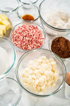 Measured ingredients in a glass mixing bowl to prepare peppermint white chocolate cookies.
