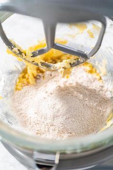 Mixing ingredients in a kitchen stand mixer to bake soft oatmeal raisin walnut cookies.