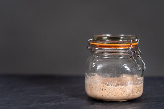 Homemade wheat sourdough starter in a glass mason jar.
