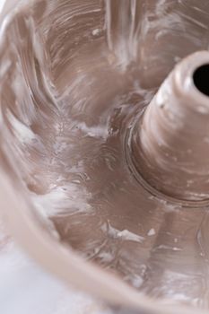 Greasing bunt cake pan to bake apple bundt cake with caramel glaze.
