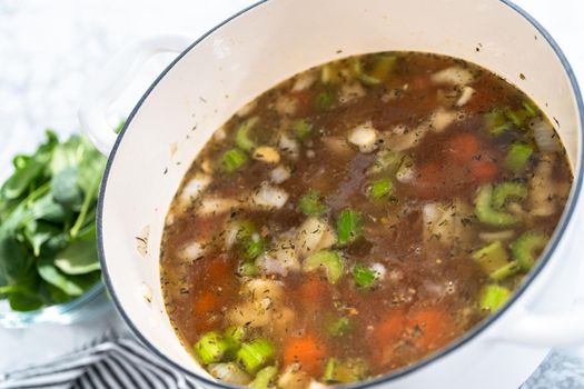 Cooking vegetarian white bean soup in cast iron dutch oven.
