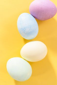 Colored hard-boiled eggs on a yellow background.