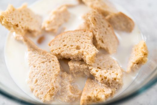 Soaking stale bread in milk to make meatloaf.