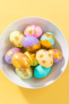 Colored and painted with gold hard-boiled eggs on a yellow background.