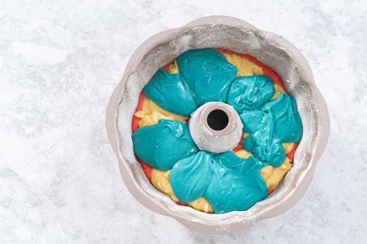 Filling bundt cake pan with red, white, and blue cake dought to bake July 4th bundt cake with chocolate stars.