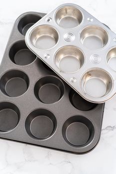Close-up view. Metal baking pans for cupcakes on a marble countertop.